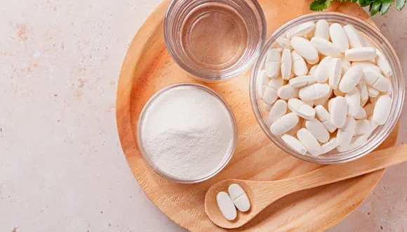 • Collagen supplements on a table with a glass of water. • A person drinking a collagen smoothie post-workout.