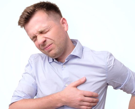 A person experiencing chest pain, clutching their chest, potentially indicating a stroke.