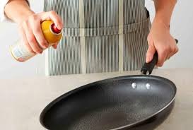 Image: Clean nonstick pan on a stovetopALT: "Pristine nonstick pan maintained without using cooking spray" Image: Person holding an oil mister above a pan ALT: "Oil mister as a healthier alternative to cooking spray for nonstick cookware" Image: Set of wooden utensils on a countertop ALT: "Wooden cooking utensils to prevent scratching nonstick surfaces" Image: Handwashing a pan in the sink ALT: "Handwashing nonstick cookware to protect its coating and extend lifespan" Image: Cookware stacked with soft protectors between ALT: "Proper storage of nonstick pans with soft dividers to prevent damage" Image: Pan with baking soda paste being scrubbed gently ALT: "Cleaning stubborn residue on nonstick pans using baking soda and water"
