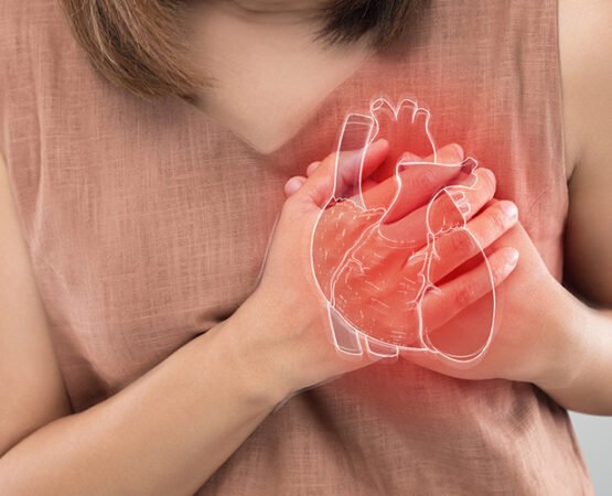 A woman holding her chest, symbolizing awareness of heart disease symptoms unique to women.